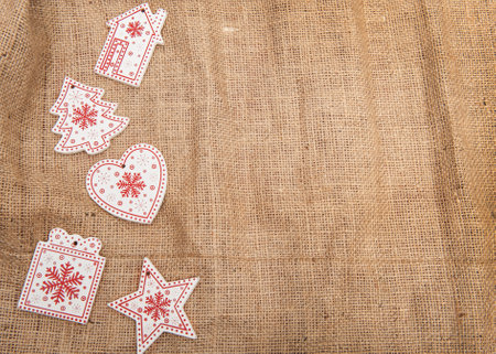 Red - white Wooden Christmas decorations on a background of burlap with artificial snow
