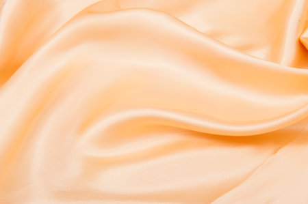 background with folds of peach-beige silkの写真素材