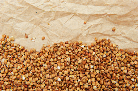 Abstract background with grains of buckwheat on crumpled old parchment wrapping paperの写真素材