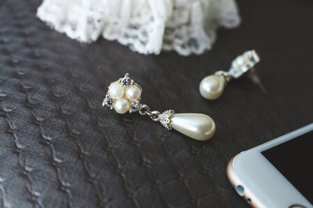 Wedding paraphernalia of the bride. Earrings. Phone. Dress.
