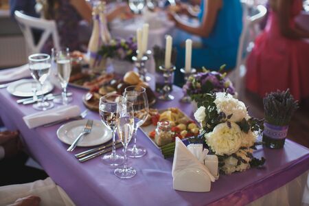 Dining table setting at Provence style, with candles, lavender, vintage crockery and cutlery,...
