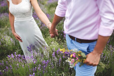 Bride and groom walking together holding their hands.の写真素材