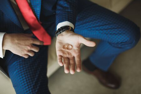 Wedding rings in hands of the groom.の写真素材