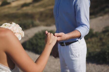 Bride and groom walking together holding their handsの写真素材