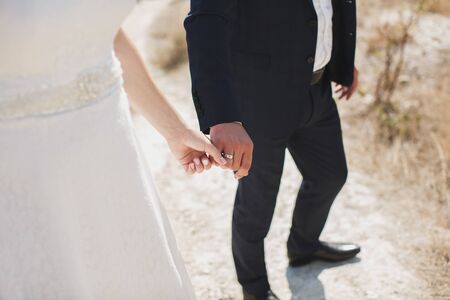 Bride and groom walking together holding their handsの写真素材