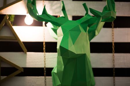 Green deer head made of paper as a close-up decor