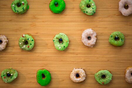 Colorful glazed donuts on a wooden backgroundの写真素材