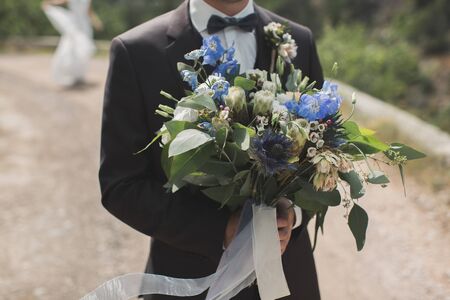 The groom meets the bride with a bouquet of flowersの写真素材
