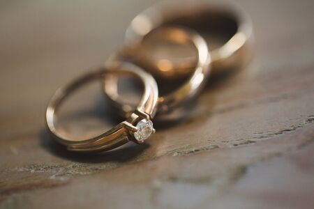 three wedding rings on a wooden backgroundの写真素材