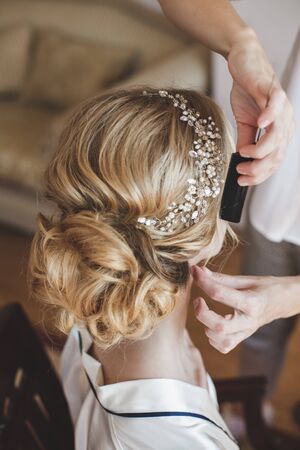 The stylist will do the bride's hair. Hairstyle with beads decorationの写真素材