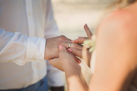 bride wears a ring on the groom's fingerの写真素材