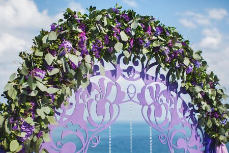 Wedding arch of purple color on the background of the seaの写真素材
