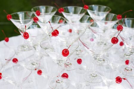 Close-up of the champagne pyramid with a red cherry at the top of each glassGlass goblets. Pyramid of champagne. A celebratory drink. Decorations for the Banquetの写真素材
