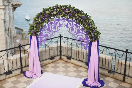 Wedding arch of purple color on the background of the seaの写真素材