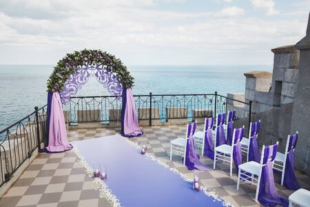 Wedding arch of purple color on the background of the seaの写真素材