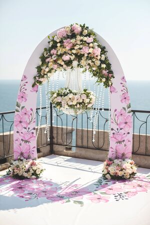 Wedding arch pink color with chandelier and flowersの写真素材