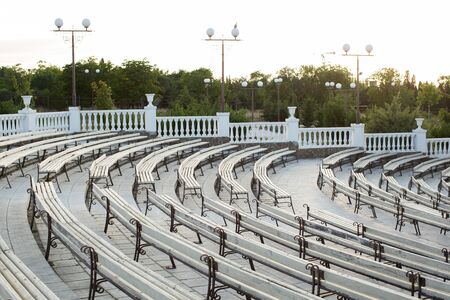 Row of wooden benches at summer theater in a city park.の写真素材