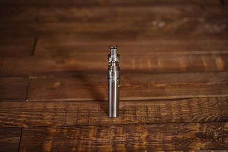 Electronic cigarette on a wooden table. Smoke.