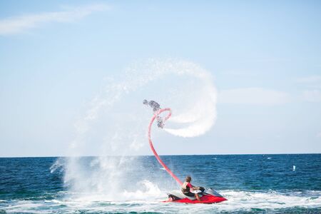 Silhouette of a fly board rider at sea.