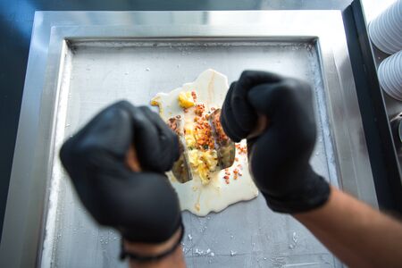 Stir-fried ice cream rolls at freeze pan. Rolled ice cream, hand made ice cream dessert. Fried ice...