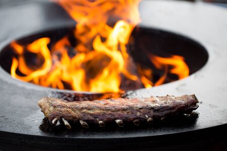 Grilled pork baby ribs with barbecue sauce on the grill. Festival street food.