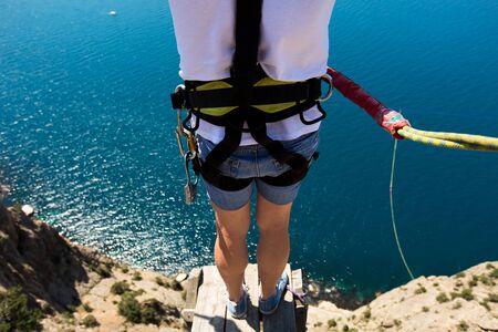 Rope jumping off a cliff with a rope in the water. The ocean. Sea. Mountain.の写真素材