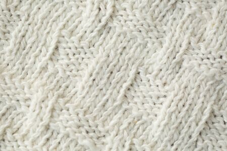 Knit texture of white wool knitted fabric with cable pattern as background