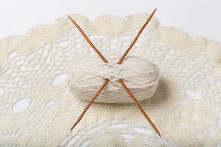 A ball of yarn and knitting on a white background.
