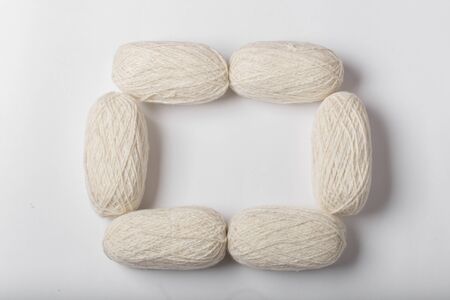 Frame made of skeins of white wool yarn.