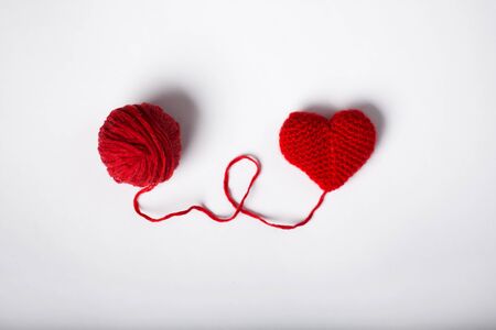 Close up of a wool ball and heart shape on white background. Heart shaped woolen yarn. Love Crochet