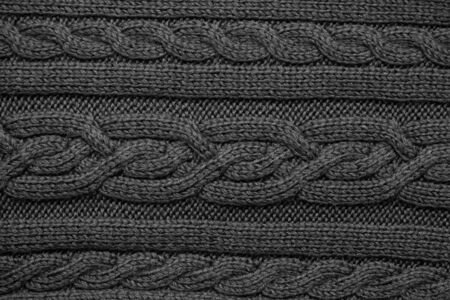 Knitted wool fabric background texture black. Ornament.