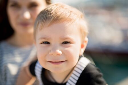 Happy mother and son on sea yacht background.の写真素材