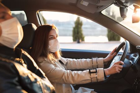 A man and a woman wearing medical masks and rubber gloves to protect themselves from bacteria and...