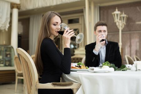 Beautiful woman and man drinking wine in restaurant.