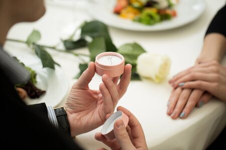 Man making marriage proposal to girlfriend at restaurant, closeup.
