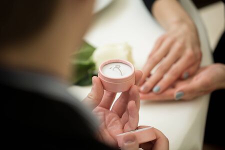 Man making marriage proposal to girlfriend at restaurant, closeup.