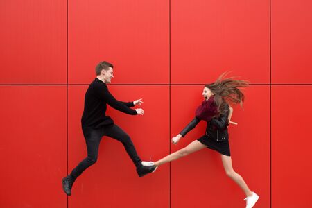 Fight in jump. A man and a woman on a red background.の写真素材