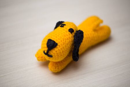 A knitted dog made of multicolored threads on a white backgroundの写真素材