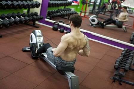 Man running rowing exercise in the gym
