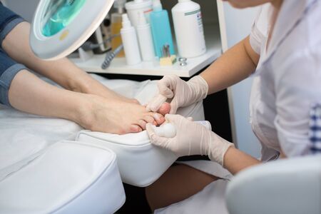 Pedicure dead skin remover foot rasp woman in nail salon. Application of the cream.の写真素材