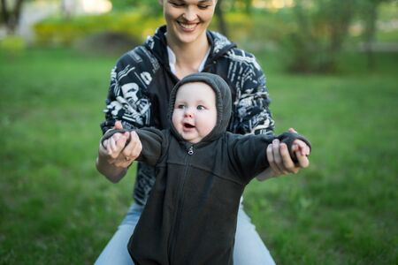 Beautiful Mother And Baby outdoors. Nature. Beauty Mum and her Child playing in Park.の写真素材