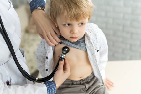 Professional general medical pediatrician doctor in white uniform gown listen lung and heart sound of child patient with stethoscopeの写真素材