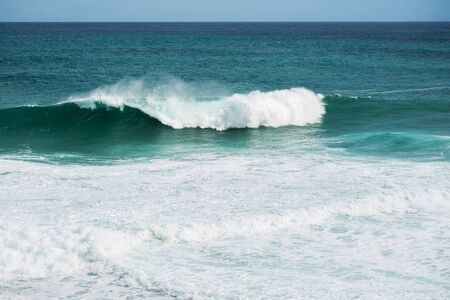 view from the beach to a tropical island and some granite rocks in the seaの写真素材