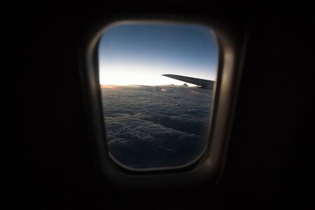 Sunrise view from the plane window on the clouds.