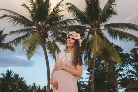 Pregnant woman in a beautiful dress on the ocean.の写真素材
