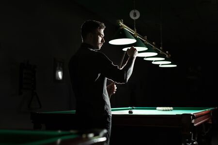A snooker player is scraping the cue.