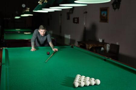Man playing in Russian billiard at bar