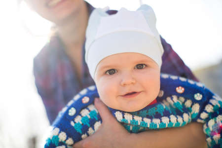 Portrait of smiling mother and baby outdoors.の写真素材
