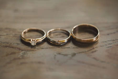 Wedding rings on a wooden texture close-upの写真素材