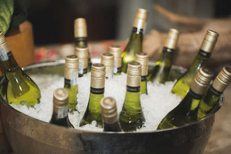 Glass bottles of wine in an ice bucketの写真素材
